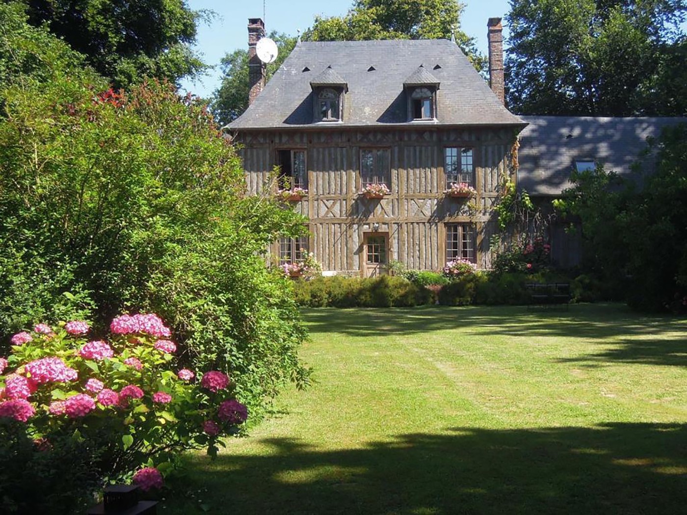 Photo d'origine : maison normande à colombages, pelouse et hortensias