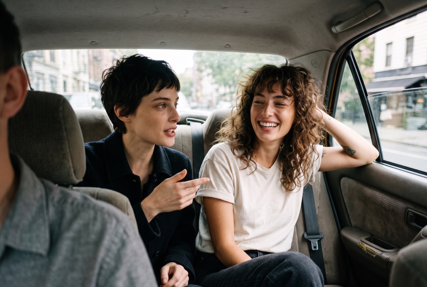 Deux amies rient à l'arrière d'un taxi